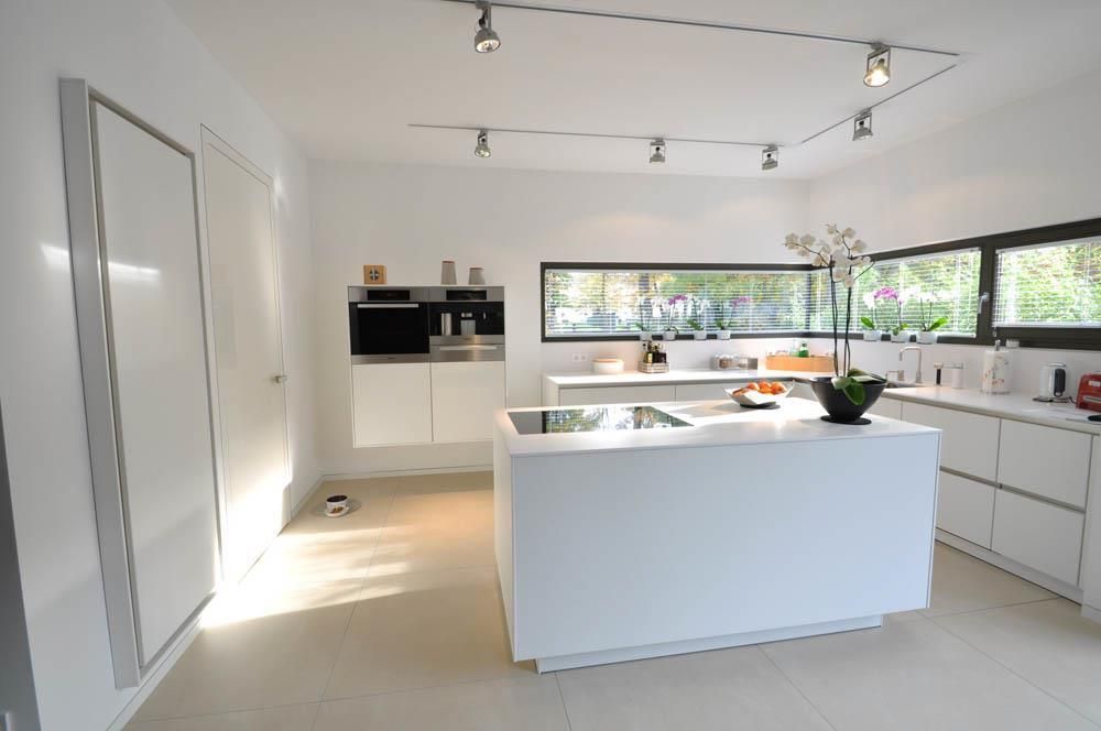 Eine Küche mit weißen Schränken und einer großen Insel in der Mitte