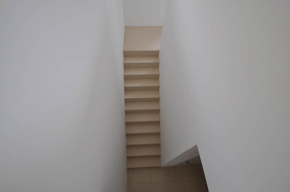 Eine Treppe, die eine weiße Wand hinaufführt