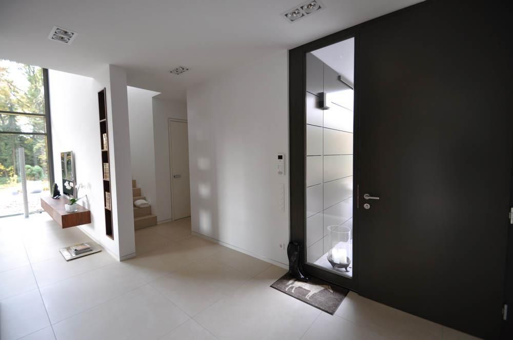 Ein Flur mit einer schwarzen Tür und einem Spiegel
