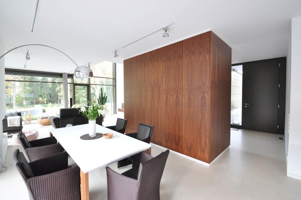 Ein Esszimmer mit einem weißen Tisch und braunen Stühlen