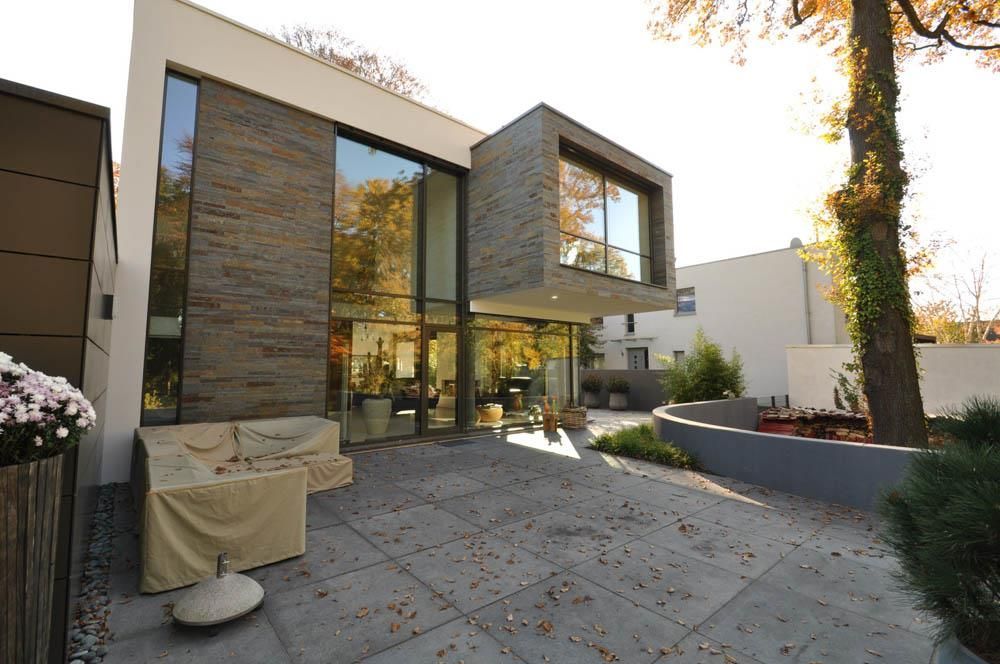 Ein großes modernes Haus mit einer Terrasse davor