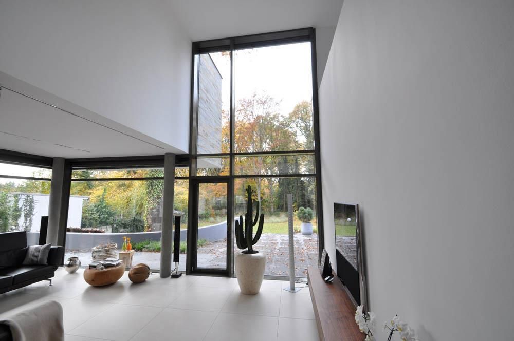 Ein Wohnzimmer mit einem großen Fenster und einem Kaktus im Topf