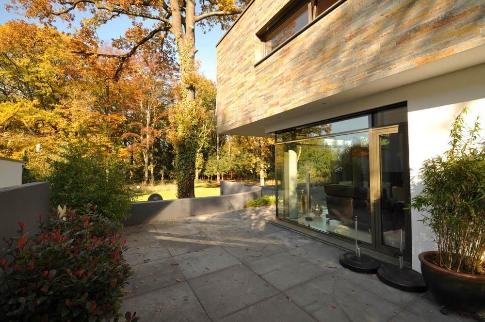 Ein Haus mit einer Terrasse und Bäumen im Hintergrund