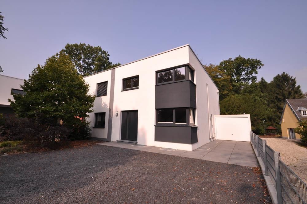 Ein weißes Haus mit schwarzen Verzierungen und einer Garage