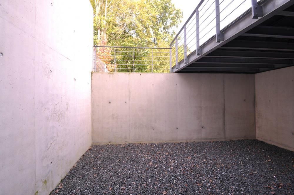 Ein leerer Raum mit Kies und einer Betonwand