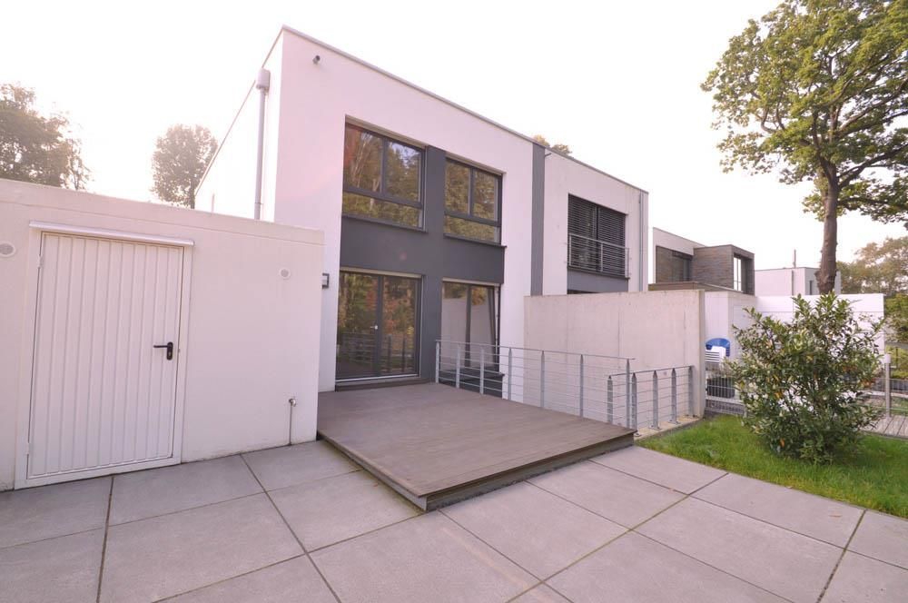 Ein großes weißes Haus mit einer Terrasse davor