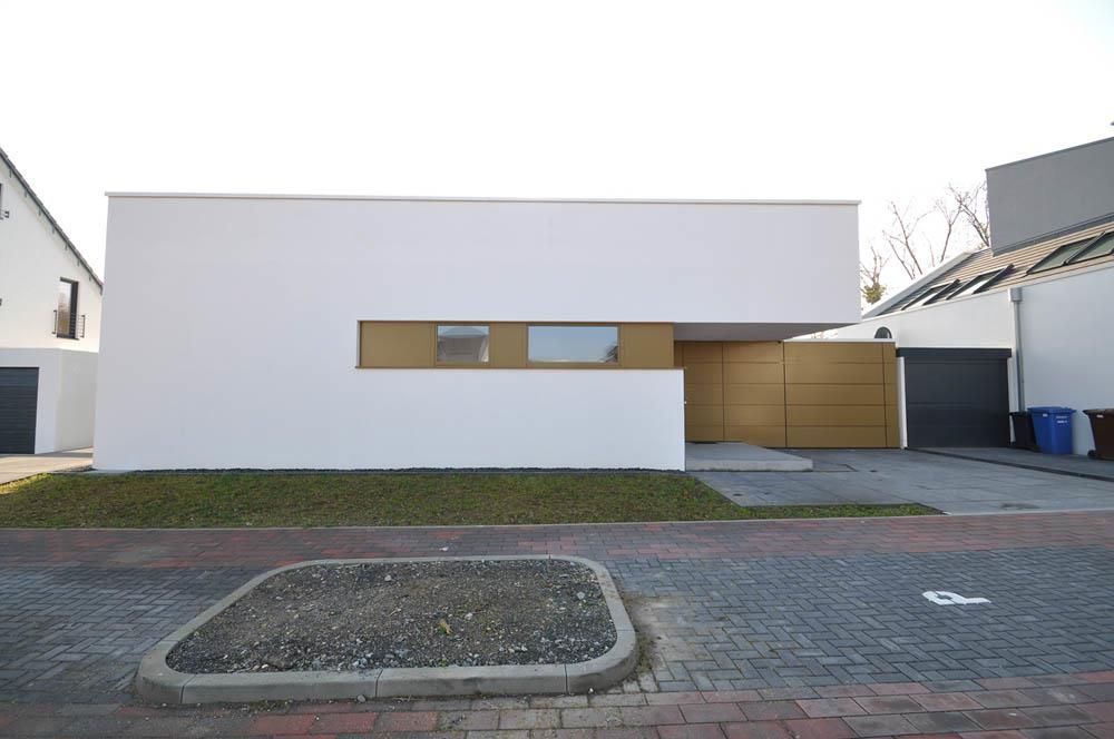 Ein weißes Haus mit einer gepflasterten Auffahrt davor