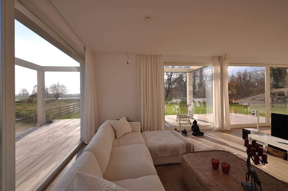 Ein Wohnzimmer mit einer weißen Couch und einem großen Fenster