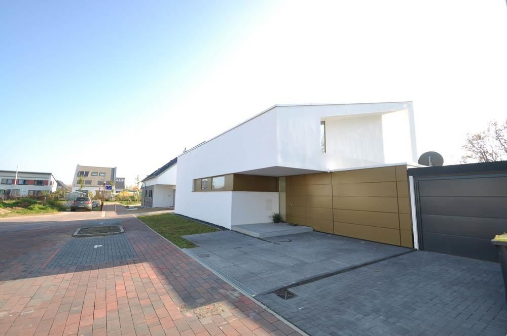 Ein weißes Haus mit einem goldenen Garagentor