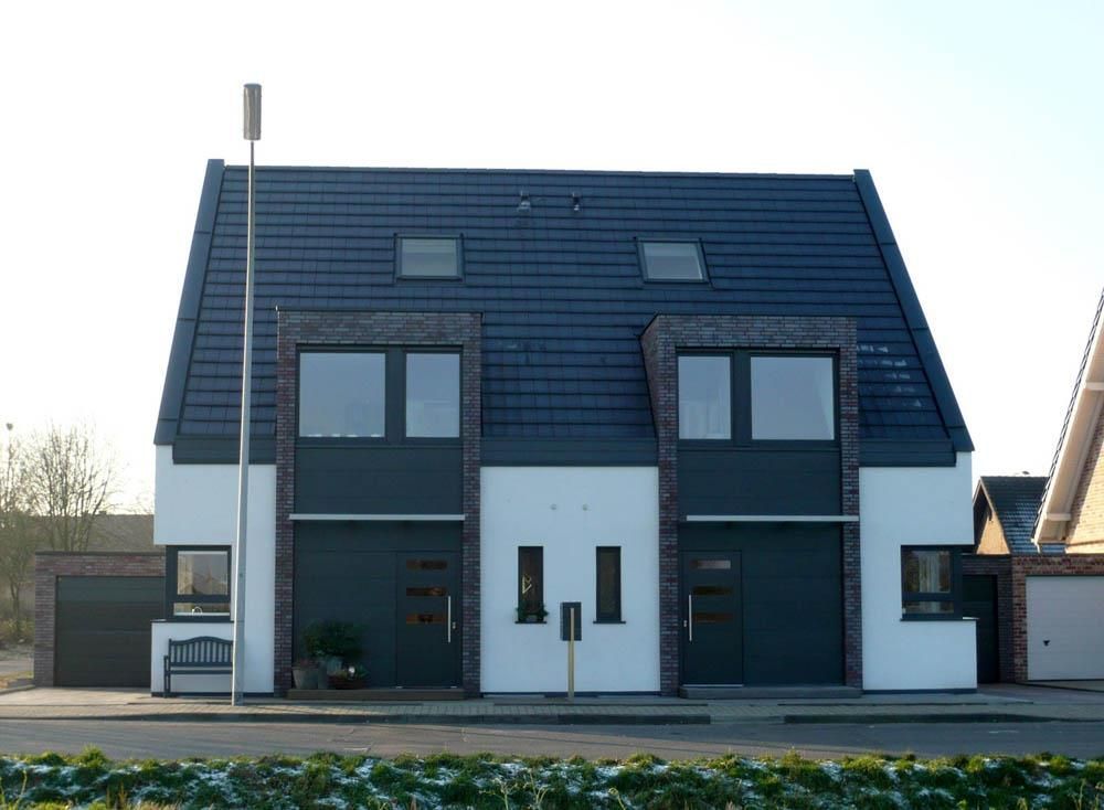 Ein weiß-schwarzes Haus mit einem schwarzen Dach