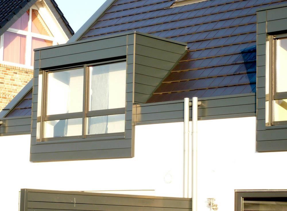 Eine Reihe von Fenstern auf einem Gebäude mit einem blauen Dach