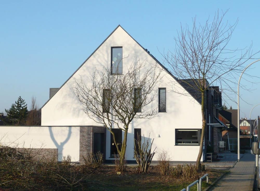 Ein weißes Haus mit einem Baum davor