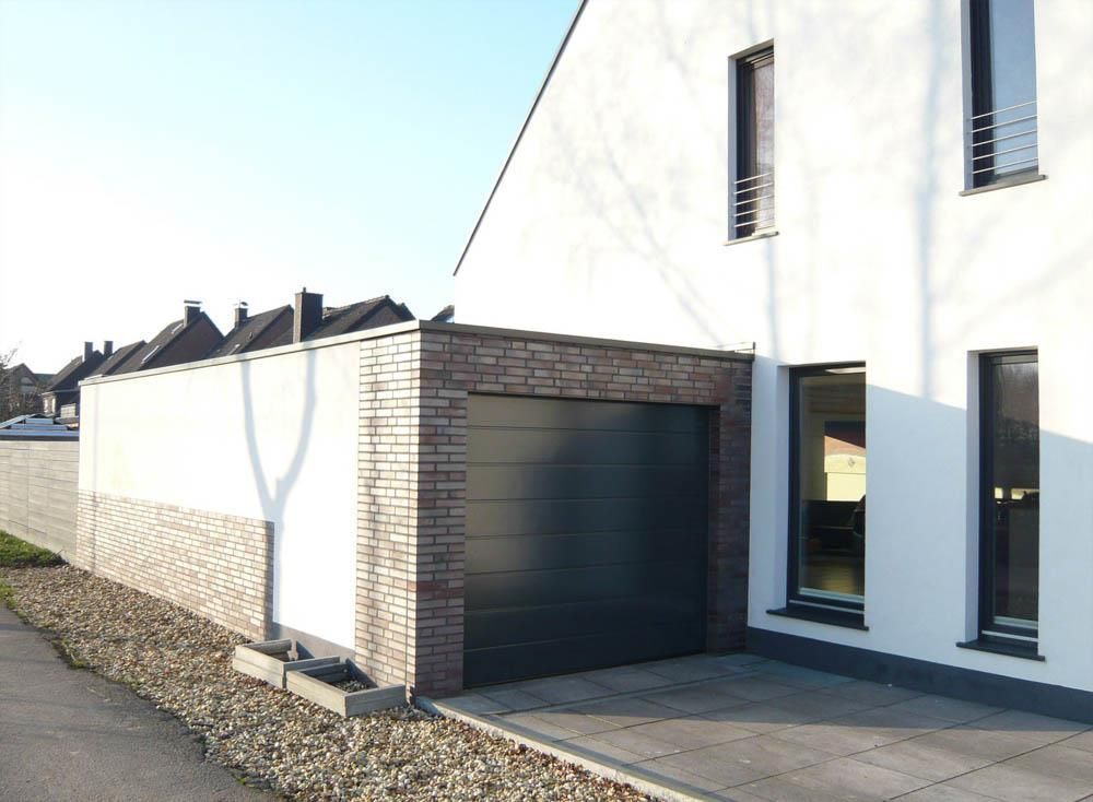 Ein weißes Haus mit einem schwarzen Garagentor