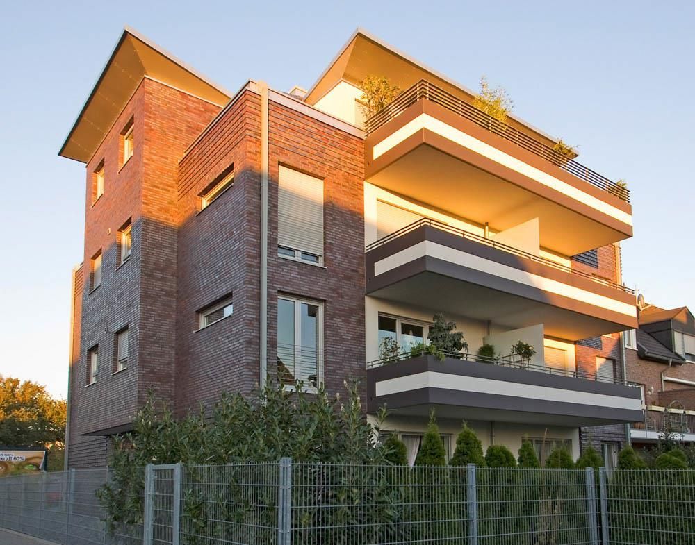 Ein großes Backsteingebäude mit einem Zaun darum