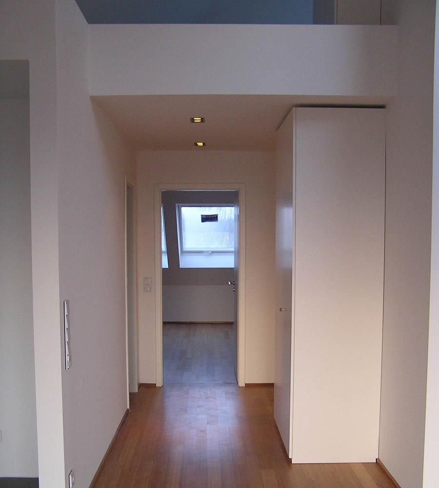 Ein Flur mit weißen Wänden und Holzböden