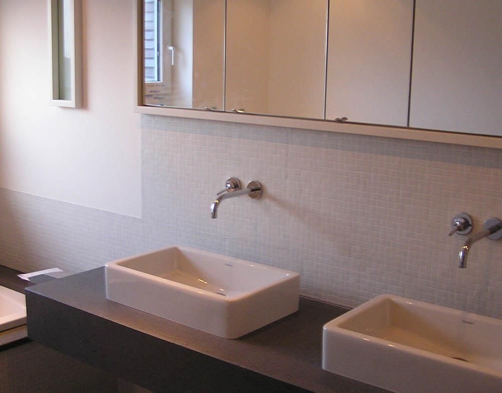 Ein Badezimmer mit zwei Waschbecken und einem Spiegel darüber