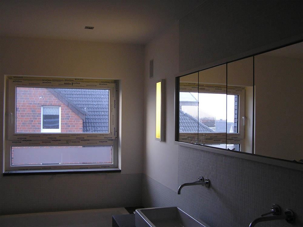 Ein Badezimmer mit Waschbecken, Spiegel und Fenster