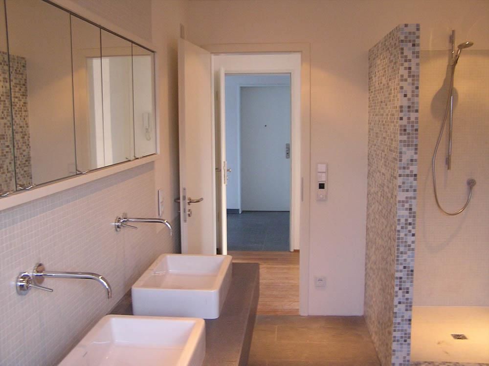 Ein Badezimmer mit zwei Waschbecken und einer ebenerdigen Dusche