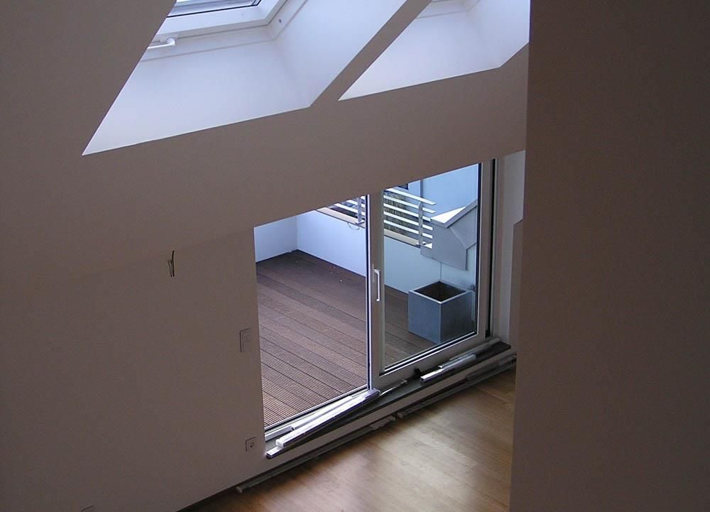 Ein leerer Raum mit einer Glasschiebetür, die zu einem Balkon führt