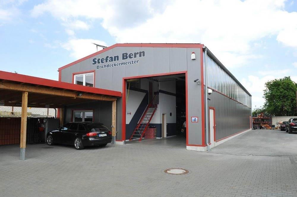 Vor einem Gebäude mit der Aufschrift „Stefan Uern“ steht ein Auto