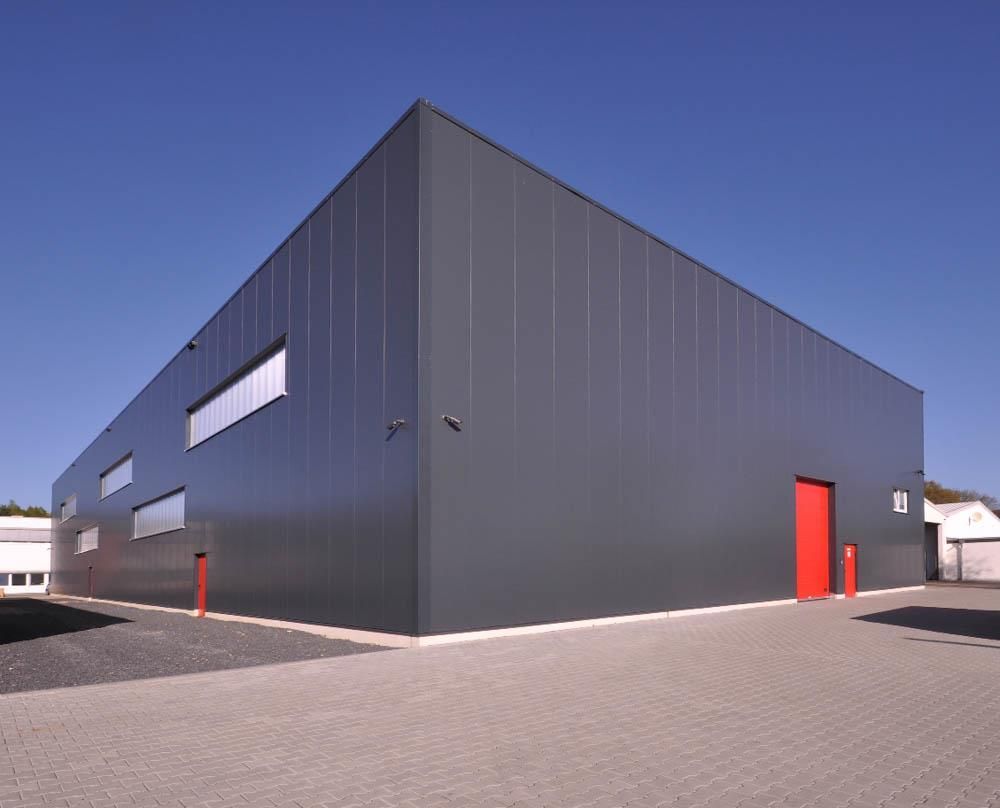 Ein großes graues Gebäude mit einer roten Tür