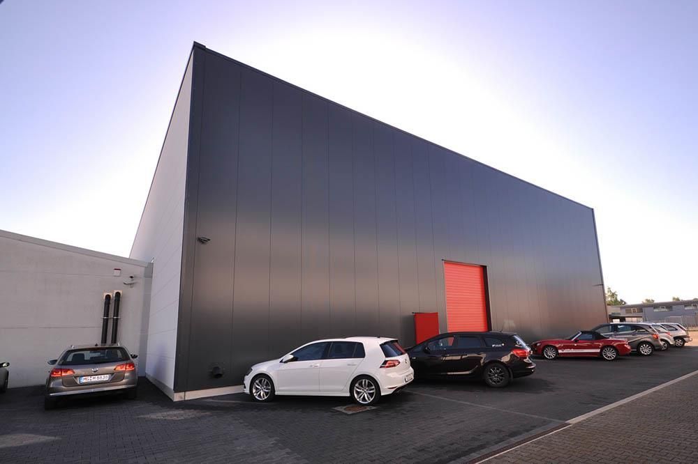 Eine Reihe von Autos parkt vor einem großen Gebäude