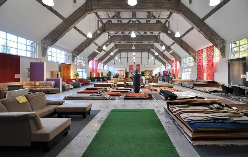 Ein großer Raum voller Möbel und einem grünen Teppich