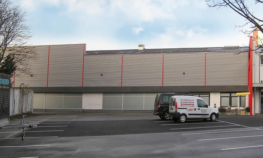 Ein weißer Lieferwagen steht vor einem großen Gebäude