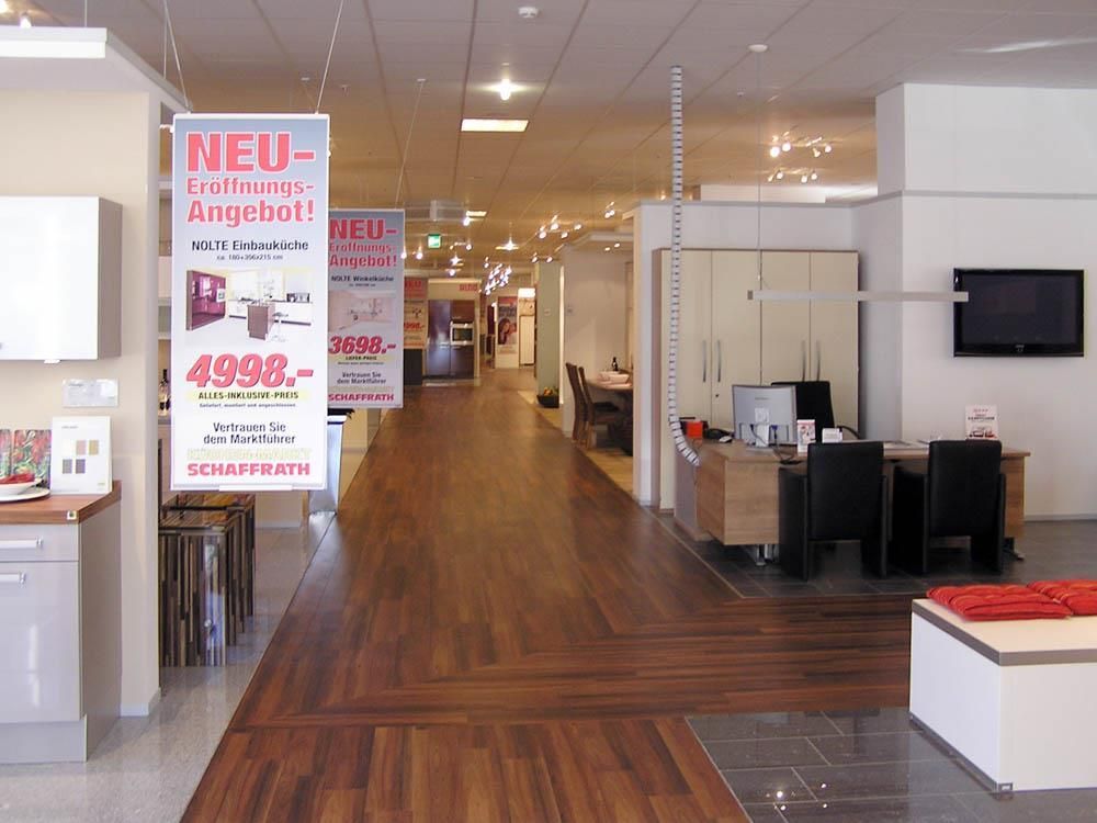 Ein großer Raum mit einem Schild mit der Aufschrift „Neues Angebot“