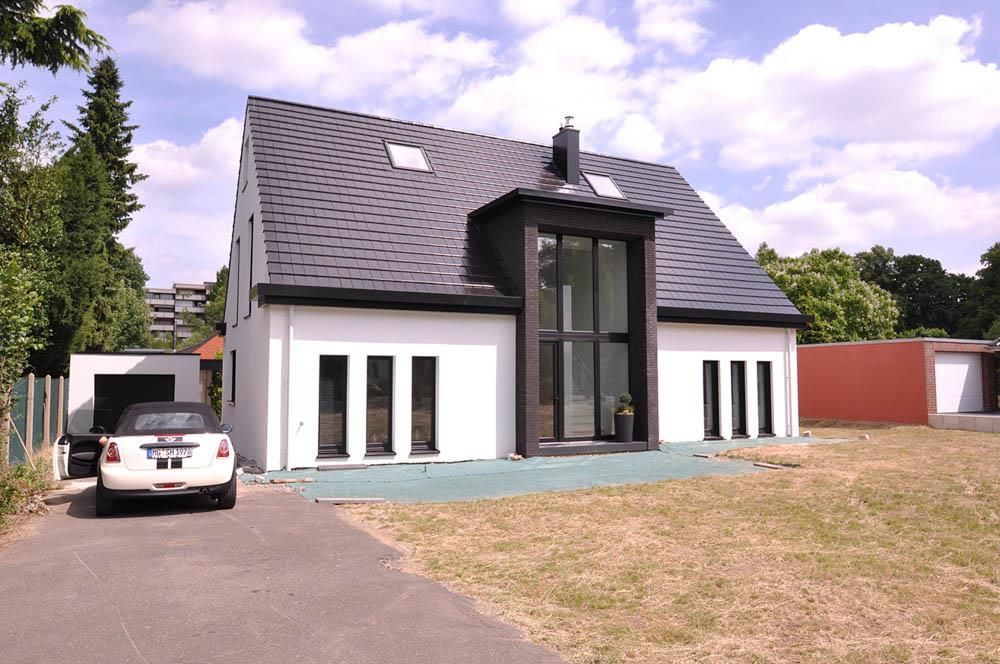 Ein weißes Auto steht vor einem weißen Haus