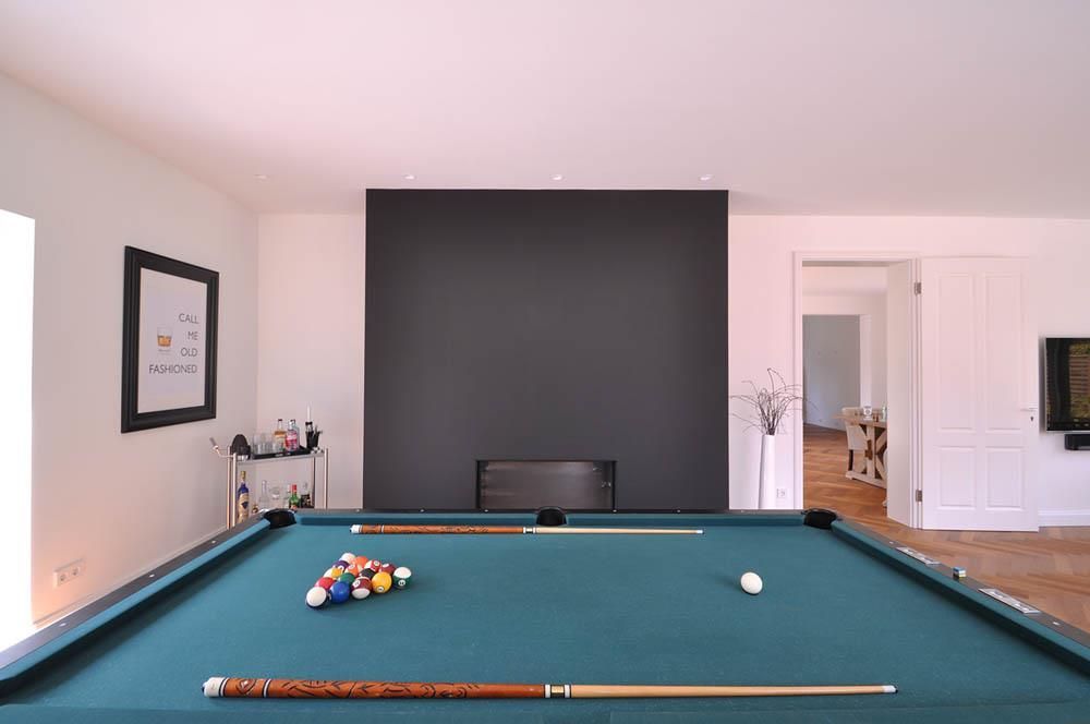 Ein Billardtisch in einem Wohnzimmer mit Kamin
