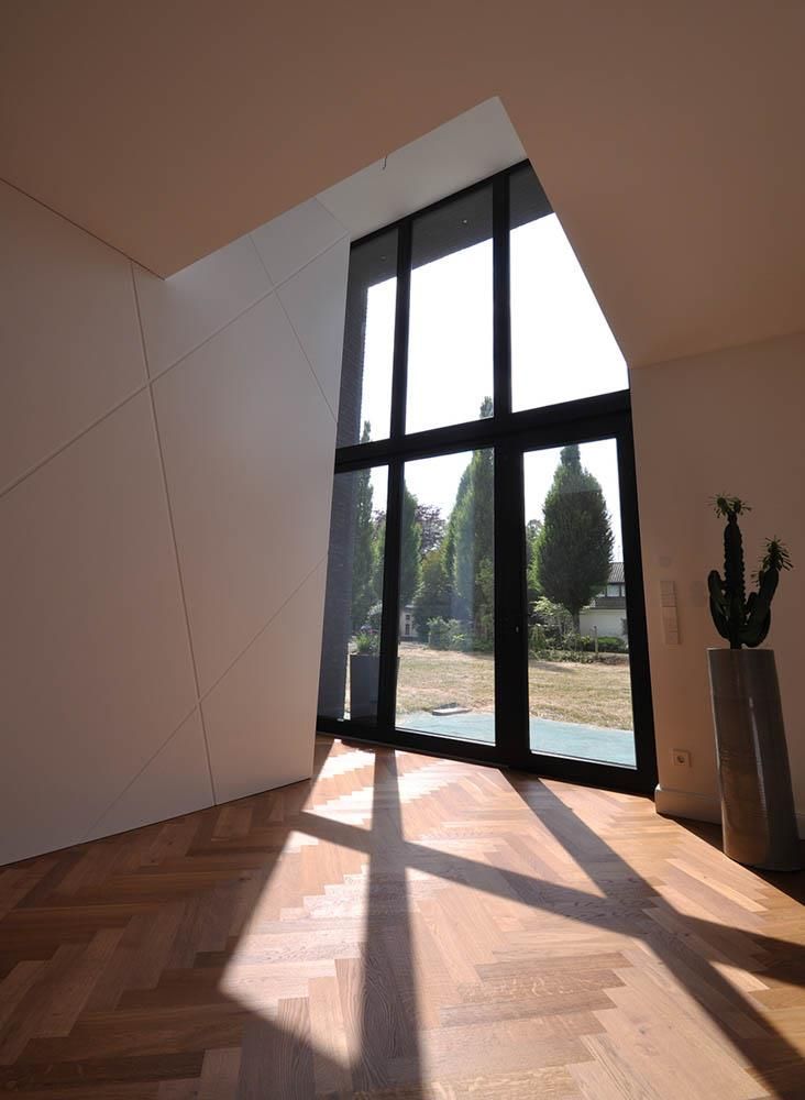 Ein Raum mit großem Fenster und Holzboden