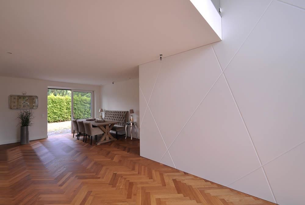 Ein Wohnzimmer mit Holzboden und weißer Wand