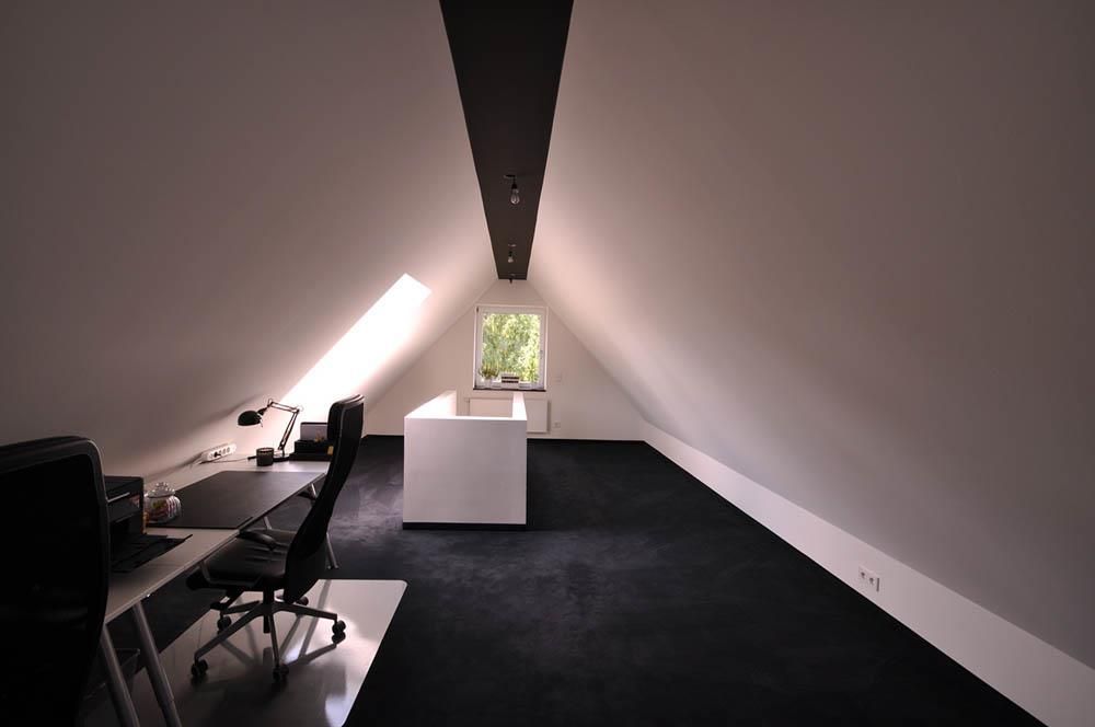 Ein Dachboden mit einem Schreibtisch und einem Stuhl darin