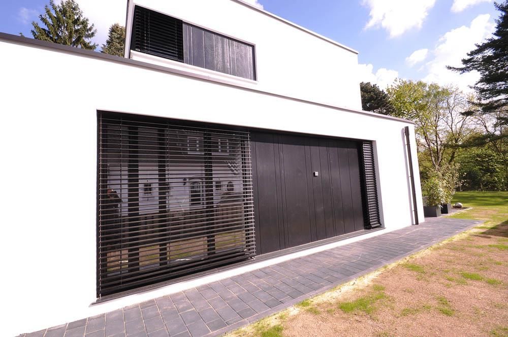 Ein weißes Haus mit einem schwarzen Garagentor