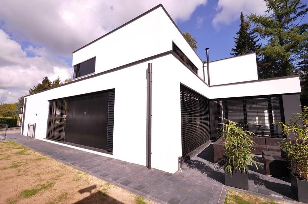 Ein weißes Haus mit einem schwarzen Garagentor