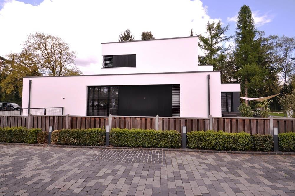 Ein weißes Haus mit einem Holzzaun darum