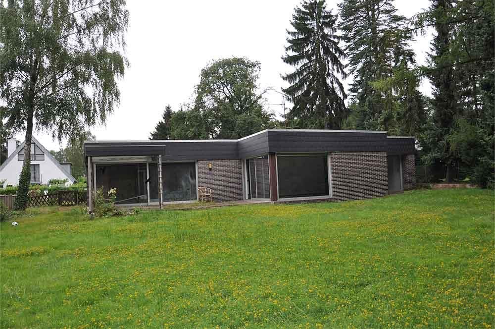 Ein Haus inmitten einer Wiese mit Bäumen im Hintergrund