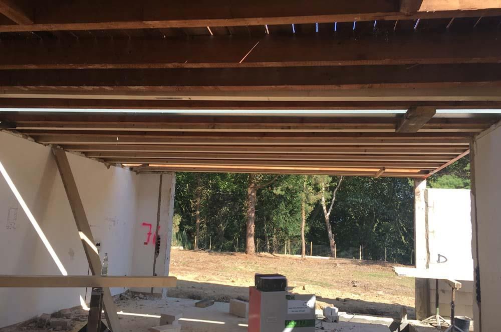 Ein im Bau befindliches Gebäude mit einer Holzdecke und Bäumen im Hintergrund