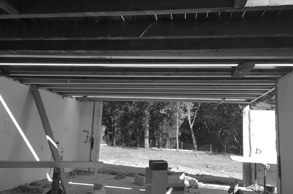 Ein im Bau befindliches Gebäude mit einer Holzdecke und Bäumen im Hintergrund