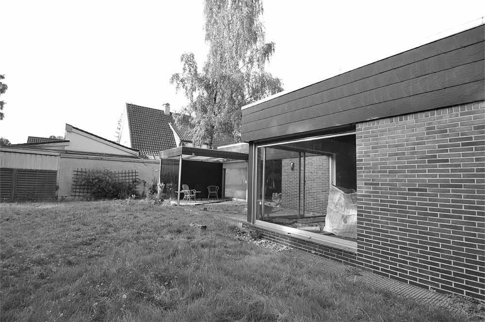 Ein Backsteinhaus mit einem großen Fenster im Hinterhof