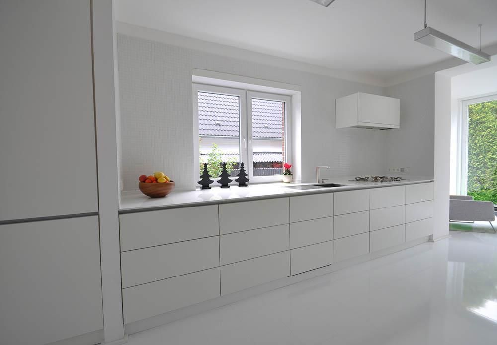 Eine Küche mit weißen Schränken und einer Obstschale auf der Theke