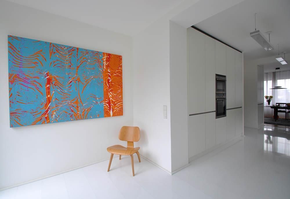 Ein Stuhl in einem Raum mit einem großen Gemälde an der Wand