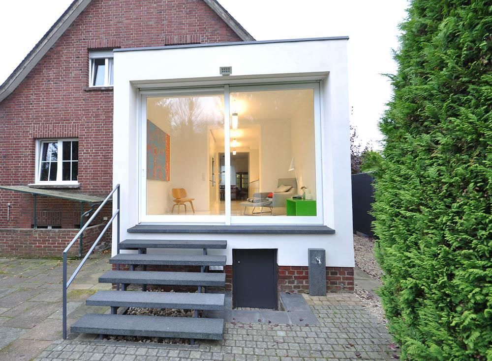 Ein Haus mit einer Treppe hinauf und einem großen Fenster