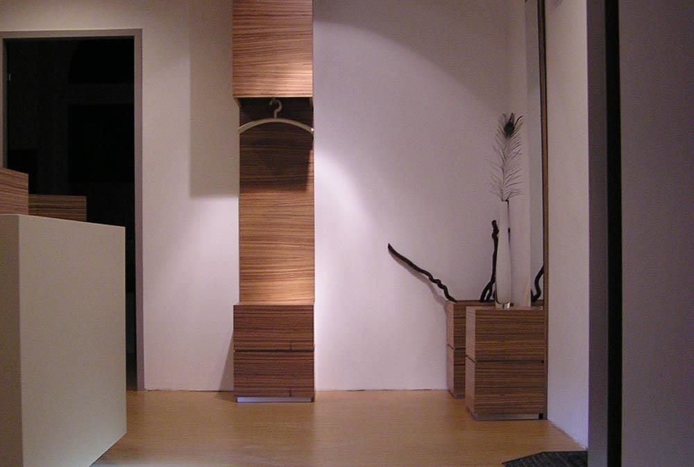 Ein Flur mit einem Holzregal und einem Kleiderbügel an der Wand