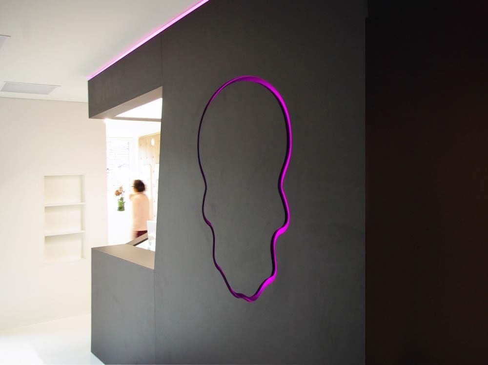 Eine schwarze Wand mit einem violetten Umriss eines Totenkopfes darauf