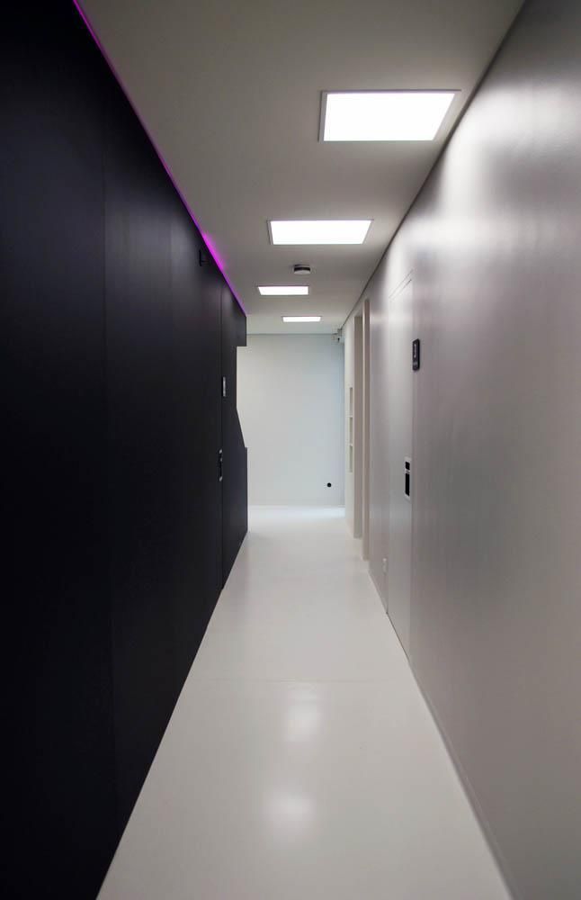 Ein langer Flur mit schwarzen Wänden und weißen Böden