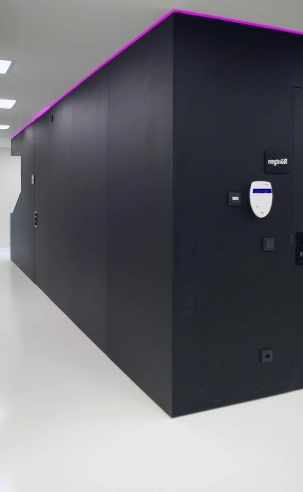 Ein langer Flur mit einer schwarzen Wand und einem weißen Boden