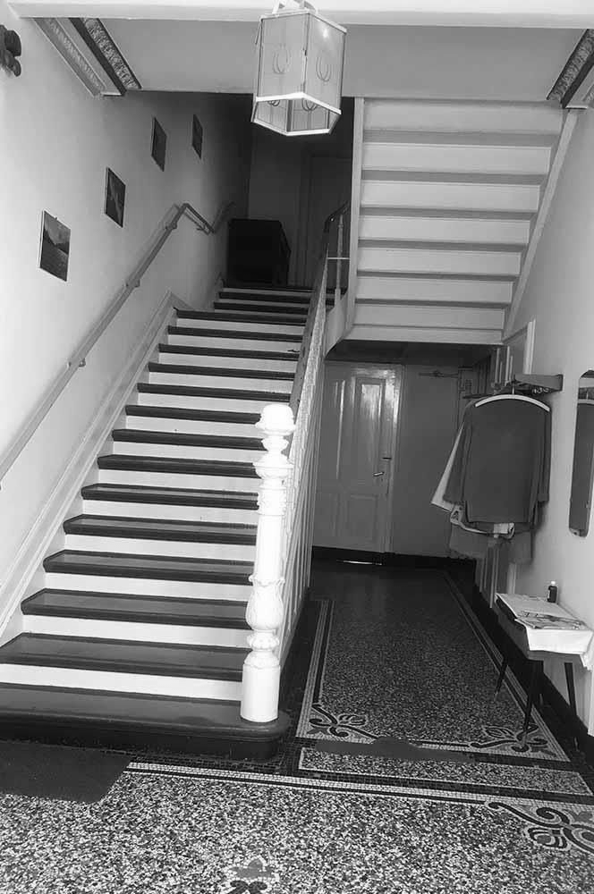 Ein Flur mit einer Treppe, die in den zweiten Stock eines Gebäudes führt.