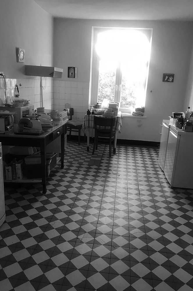 Eine Küche mit kariertem Boden und Fenster.